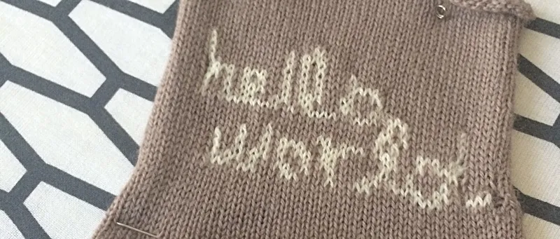 &#x27;Hello World&#x27; knit in white into brown fabric